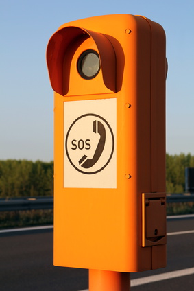 Bild einer orangfarbenen Notrufsäule mit SOS-Symbol darauf.